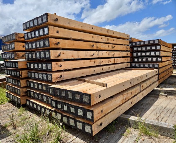 Angled view of stacked eucalyptus crane mats in storage yard