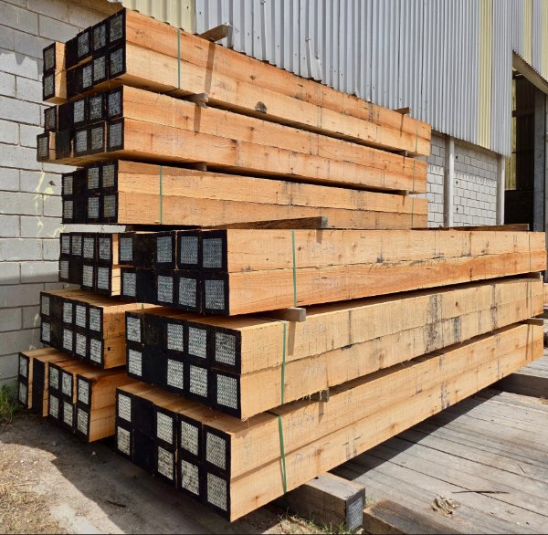 Plantation-grown eucalyptus timbers staged and prepared for precision assembly
